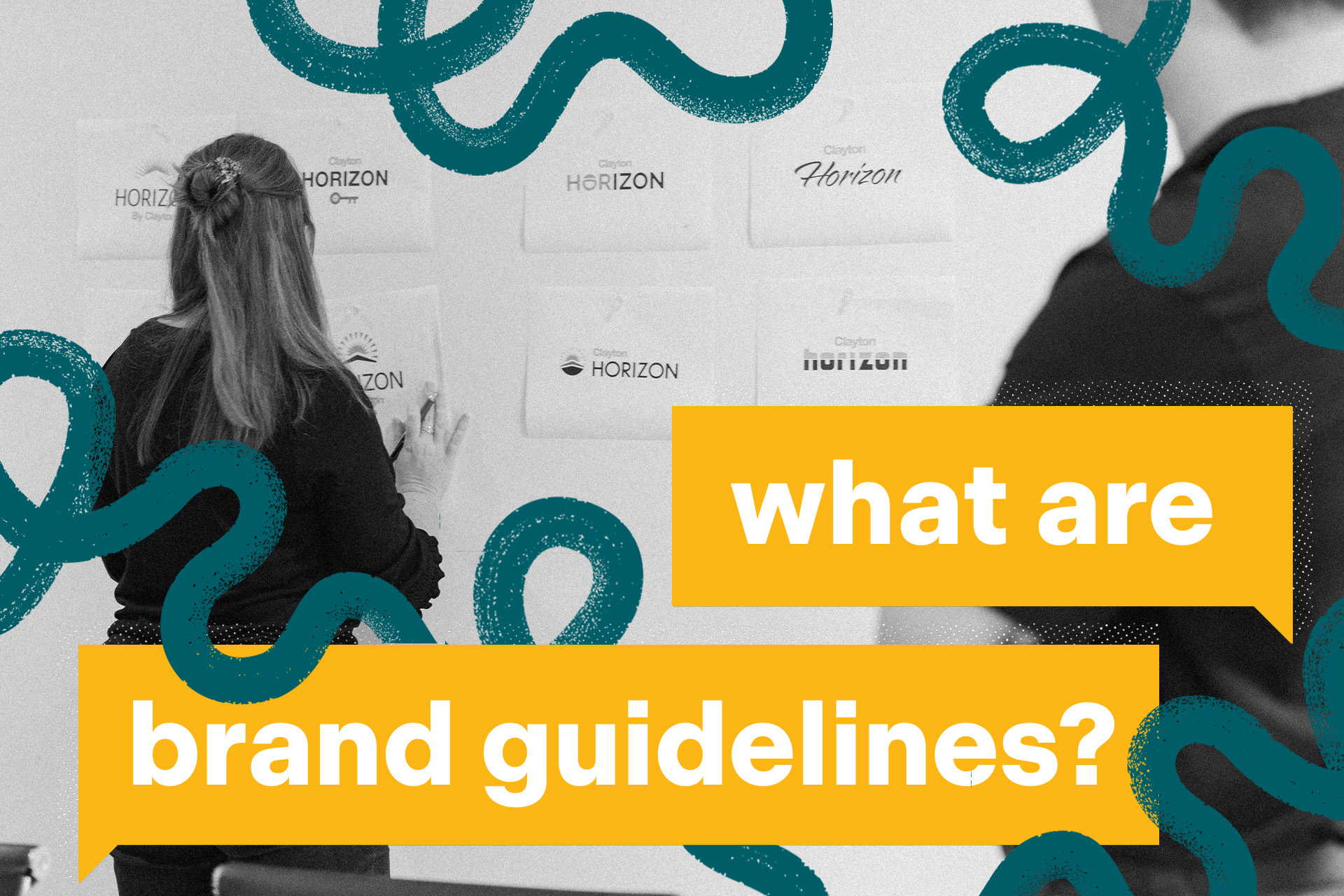 A man and woman observe a wall covered in multiple logos.